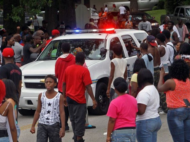 Protesters bang on the side of a police car Sunday evening,