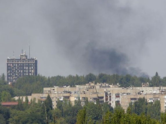 Smoke from shelling rises over a residential apartment blocks in Donetsk on 10 August
