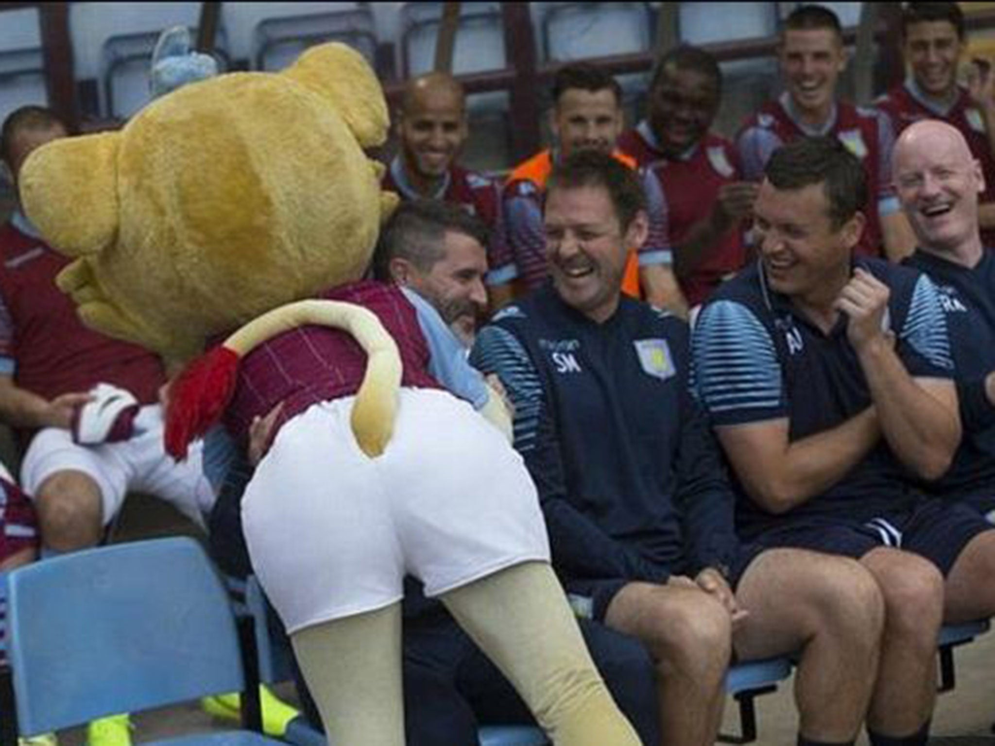 Roy Keane cracks a smile after being cuddled by Aston Villa mascot Bella the Lion