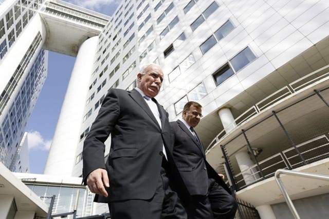 Palestinian Foreign Minister Riad al-Malki, left, leaves the International Criminal Court in The Hague, on August 5, 2014