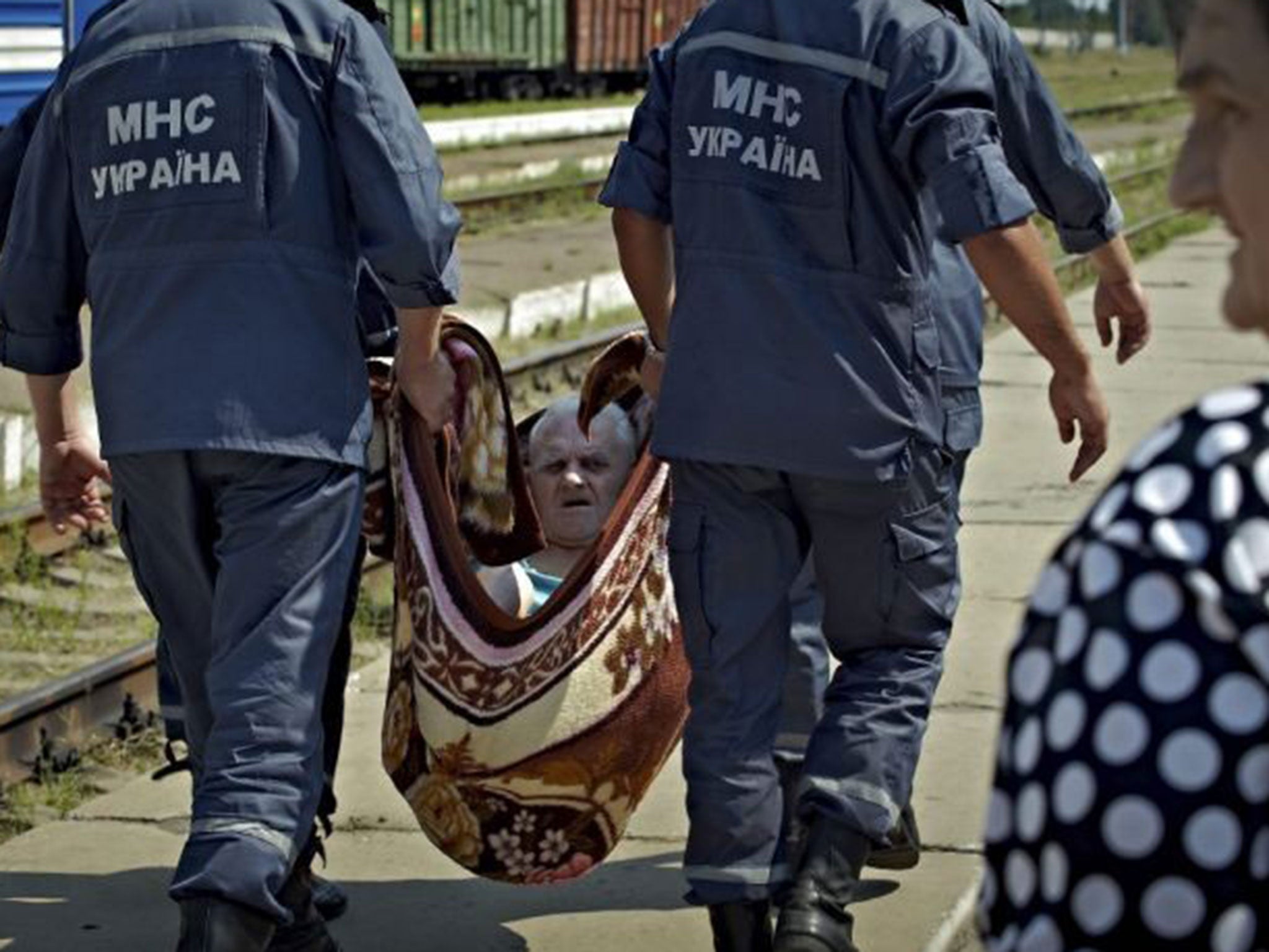 Ukrainian rescuers helping refugees from eastern Ukraine in Svatovo village, Luhansk area, Ukraine, 12 August 2014, as they arrive to a temporary refugee camp.