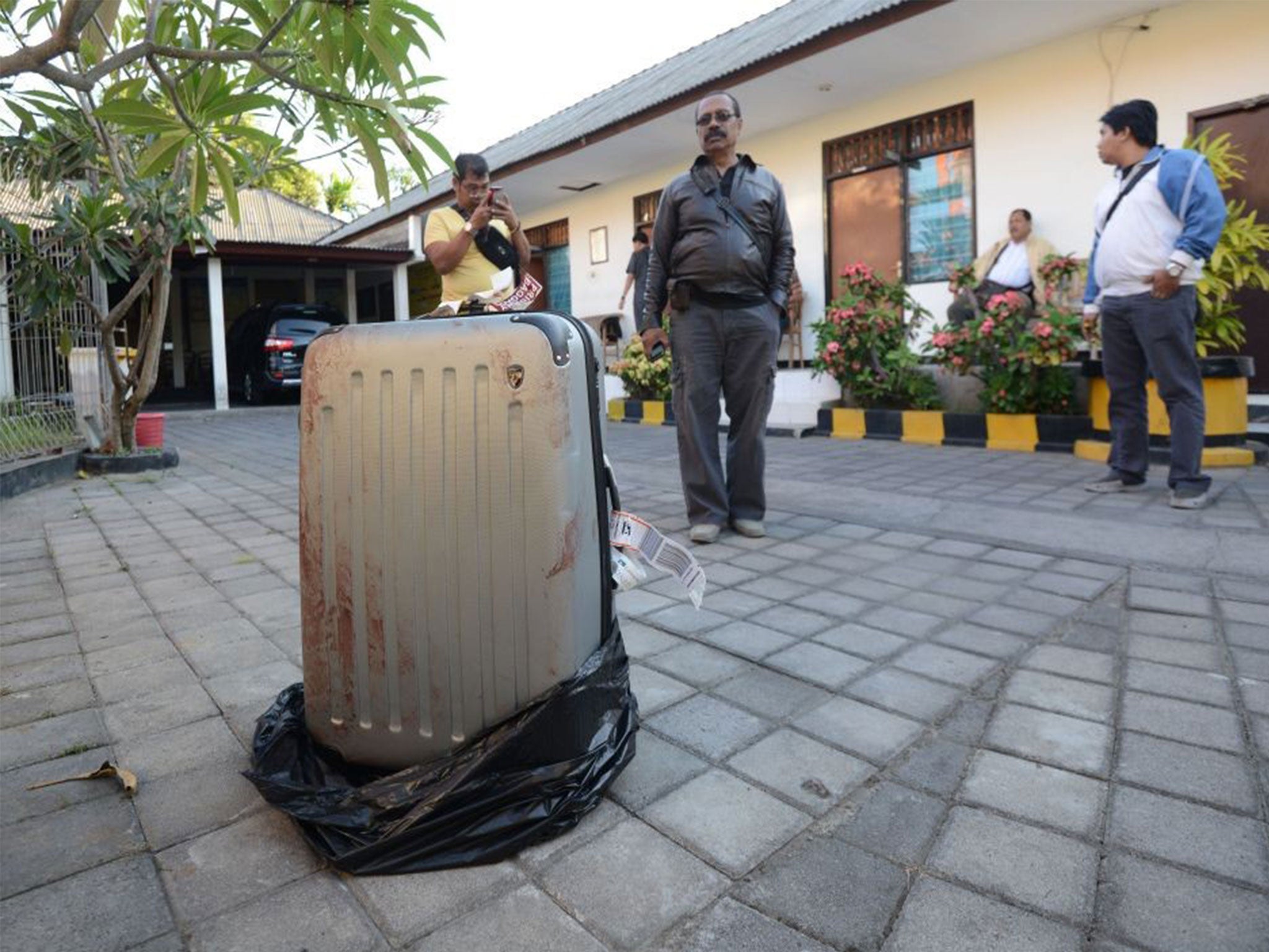 The bloody suitcase outside the St. Regis containing victim’s body