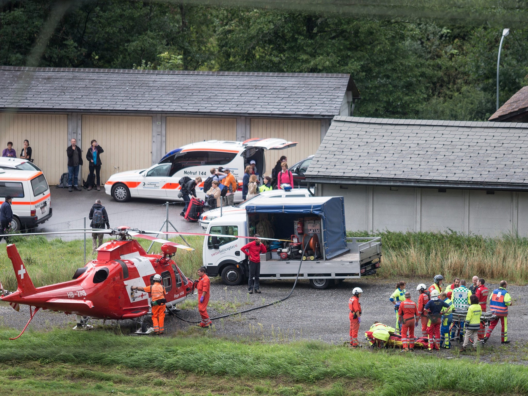 Rescue services tend to a victim of the passenger train accident near Tiefencastel, Switzerland