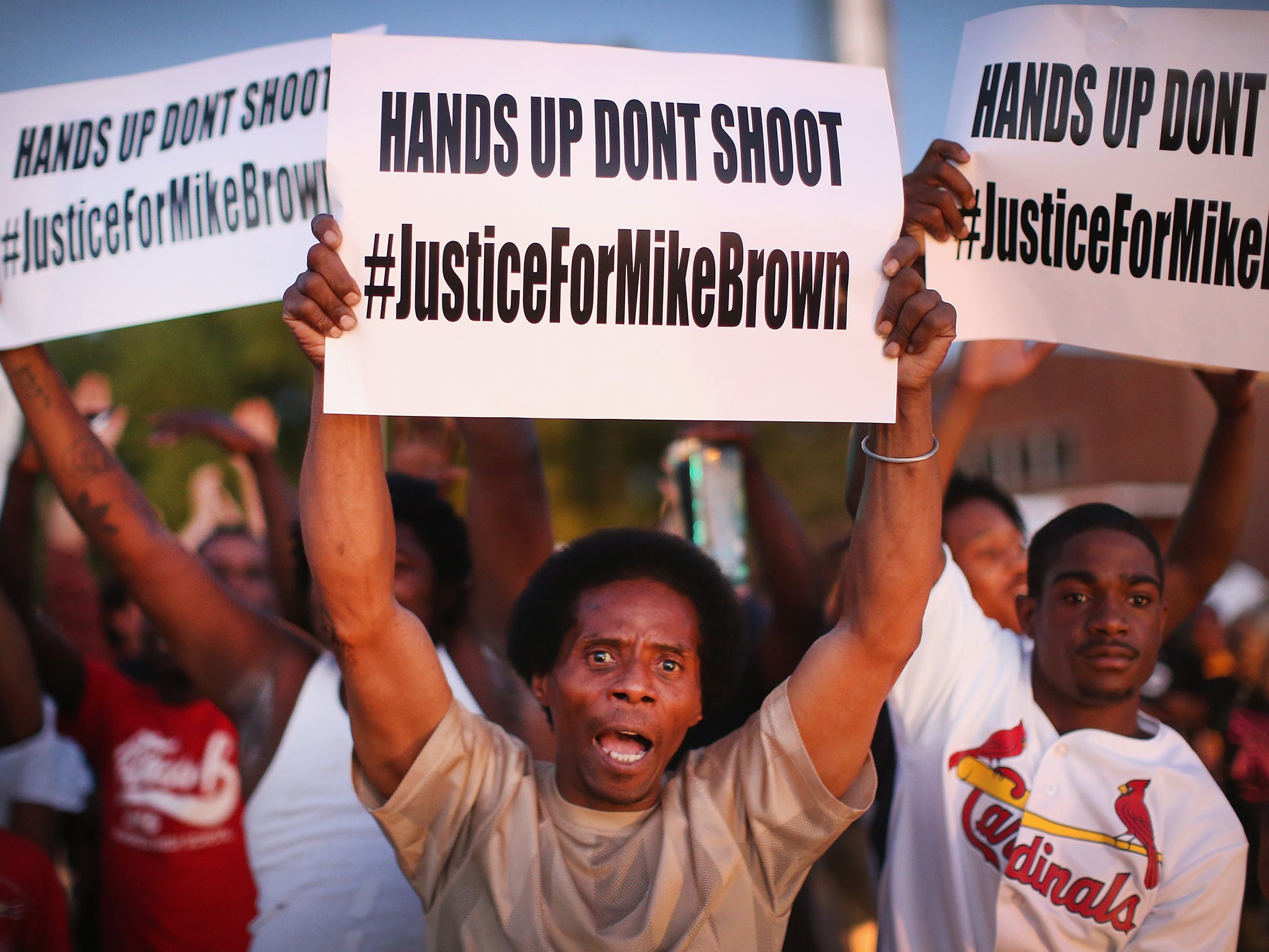 Demonstrators protest the killing of teenager Michael Brown outside Greater St. Marks Family Church