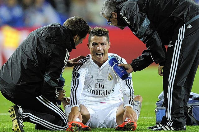 Cristiano Ronaldo receives attention from Real Madrid physios during the Super Cup win over Seville
