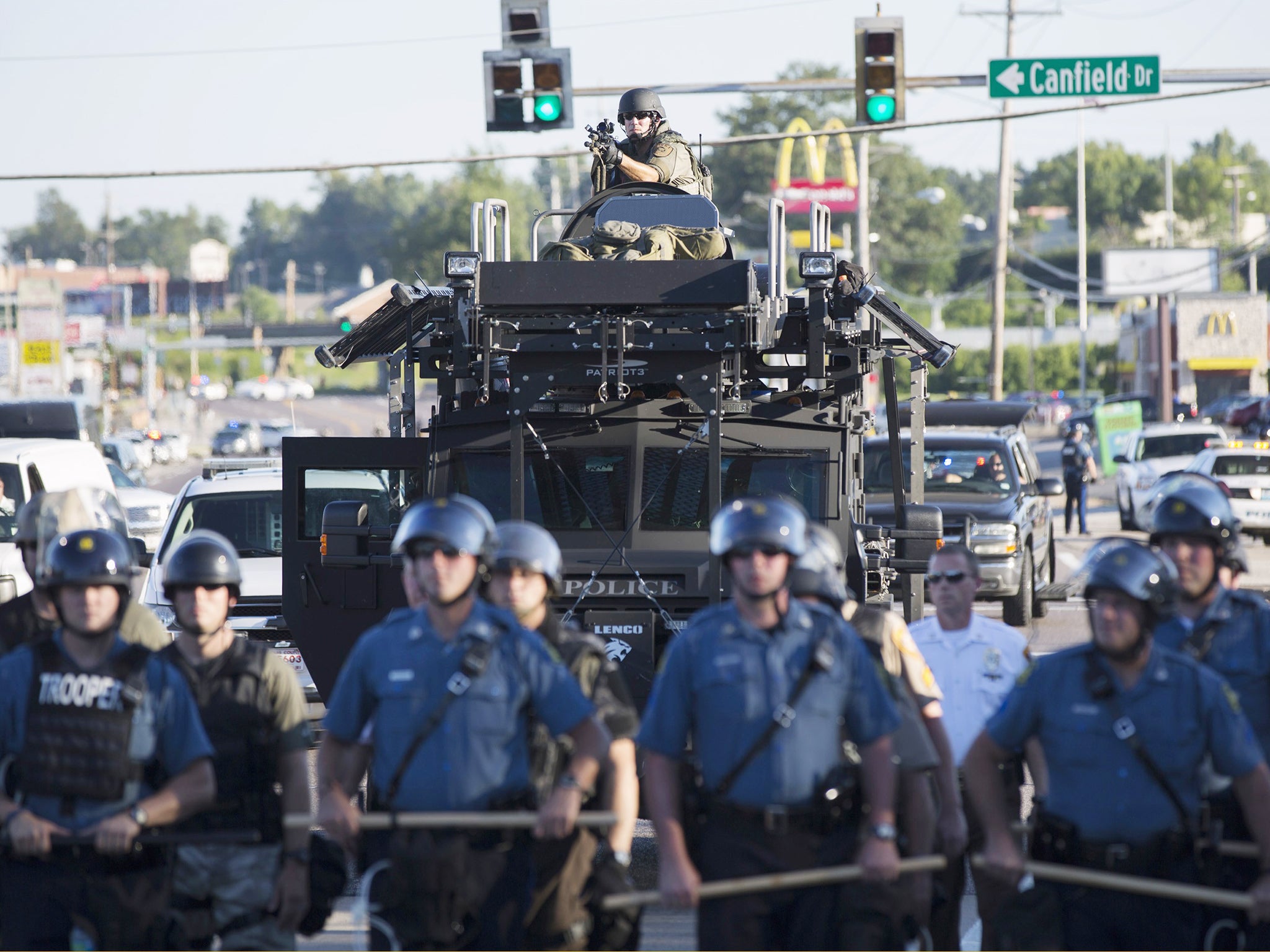 Riot police stand guard as demonstrators protest the shooting death of teenager Michael Brown in Ferguson