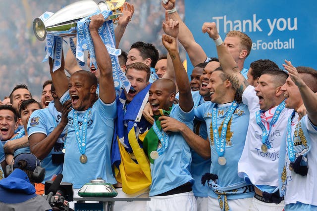 Manchester City's Belgian midfielder Vincent Kompany celebrates with the trophy after his team won the Premiership title on May 11, 2014.