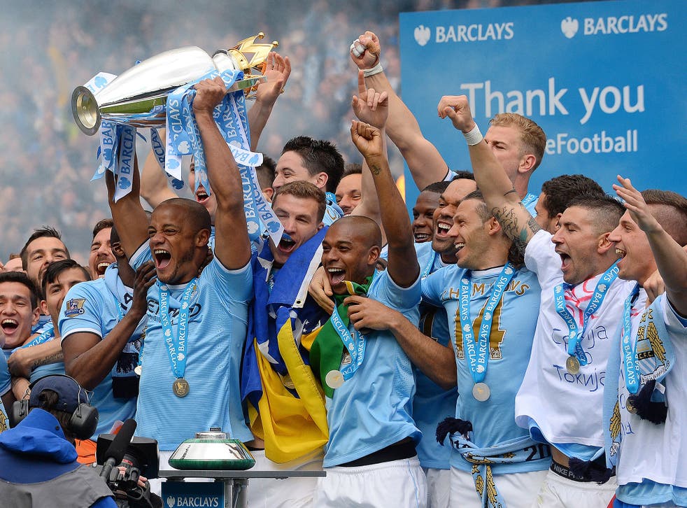 Manchester City's Belgian midfielder Vincent Kompany celebrates with the trophy after his team won the Premiership title on May 11, 2014.