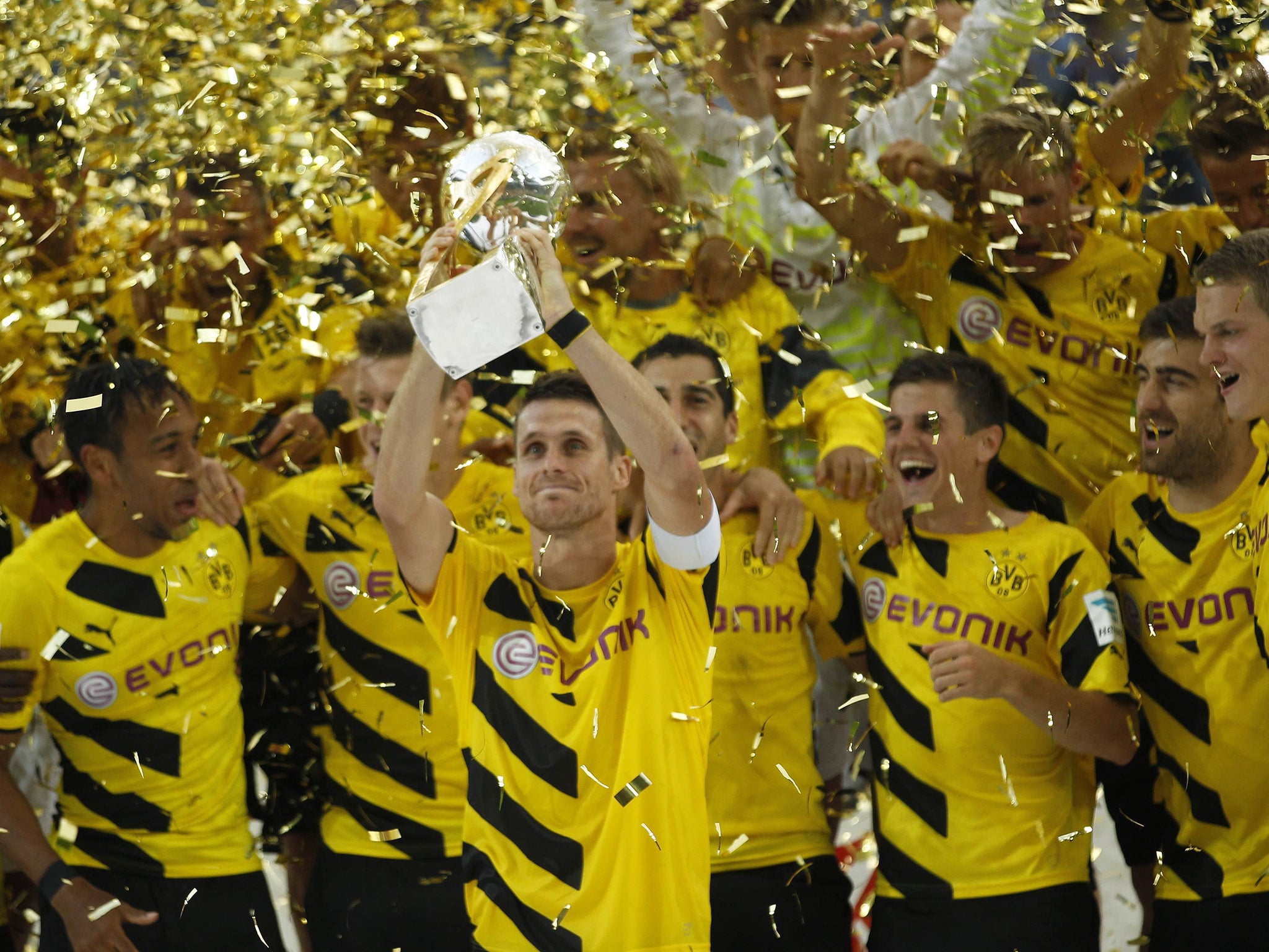 Borussia Dortmund's Sebastian Kehl lifts the German SuperCup soccer trophy after their victory over Bayern Munich in Dortmund