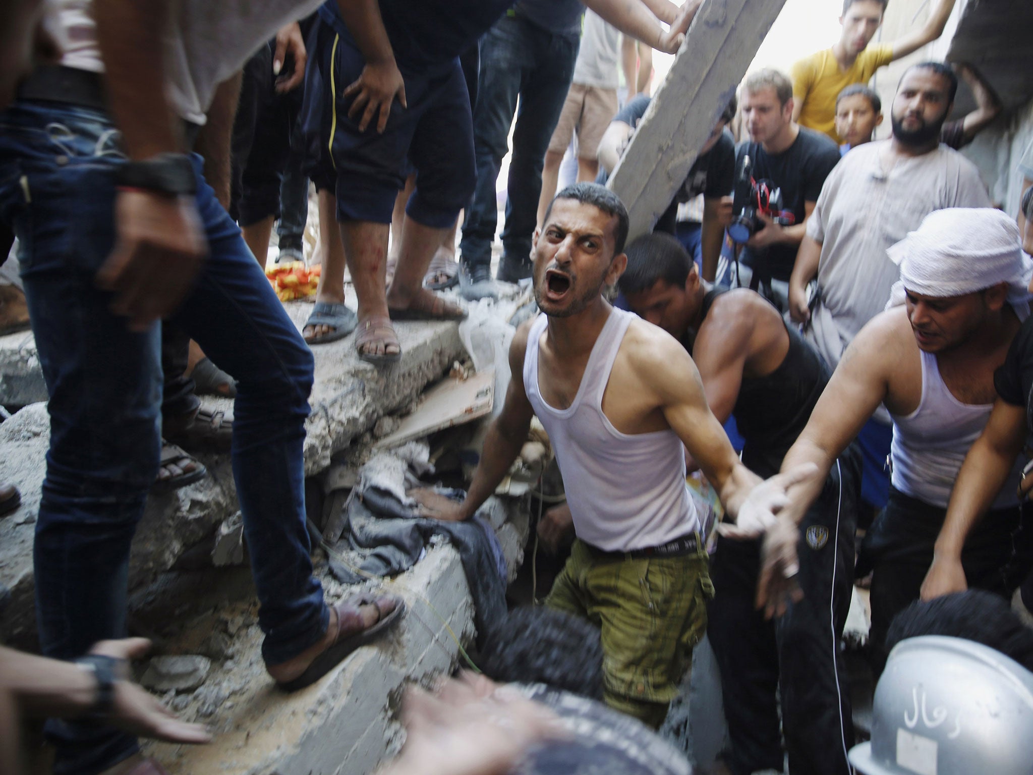 An appalling and unrelenting cycle: Palestinians dig through the rubble of a building searching for bodies