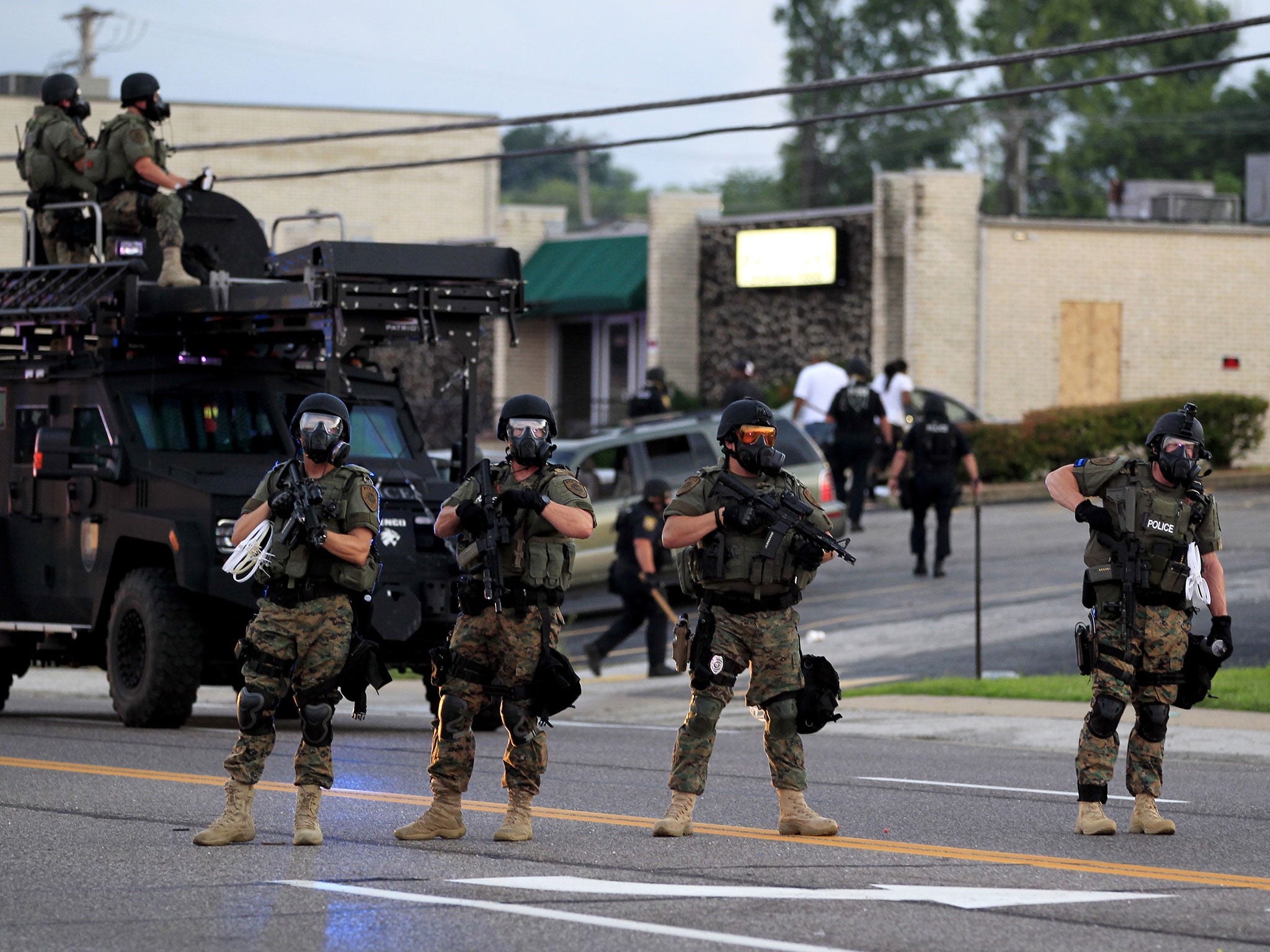 Police wearing riot gear try to disperse a crowd in Ferguson, Missouri