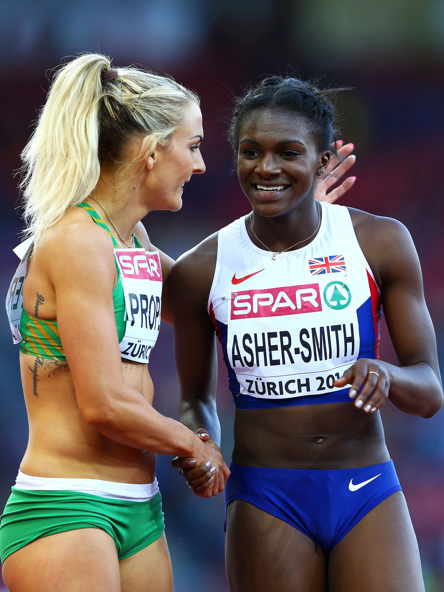 Dina Asher-Smith of Great Britain and Northern Ireland and Kelly Proper of Ireland speak after the Women's 200 metres semi-final on day three of the 22nd European Athletics Championships