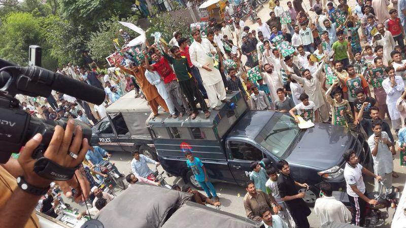 Protesters atop a police van in Gujranwala