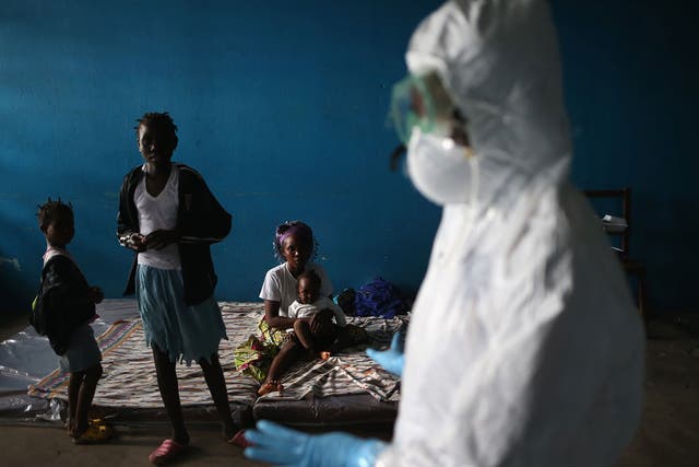A Liberian health worker speaks with families in a classroom now used as an Ebola isolation
ward in Monrovia, Liberia