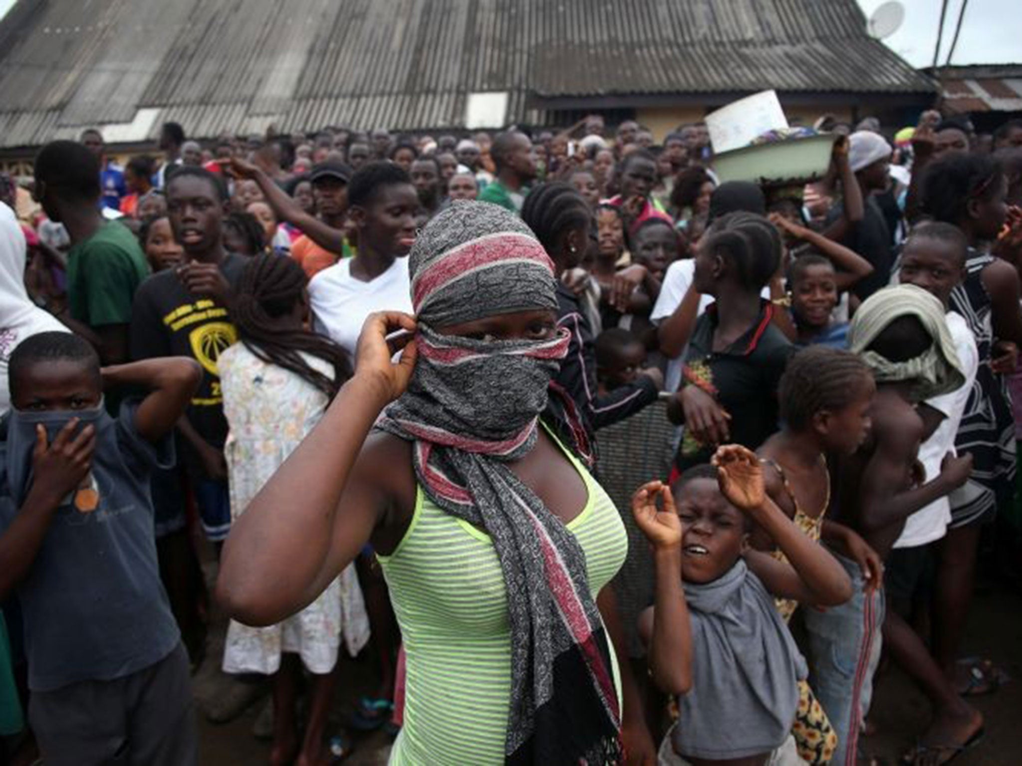 A crowd enters the grounds of an Ebola isolation center in the West Point slum on August 16, 2014 in Monrovia, Liberia. A mob of several hundred people, chanting, "No Ebola in West Point," opened the gates and took out the patients, many saying that the E