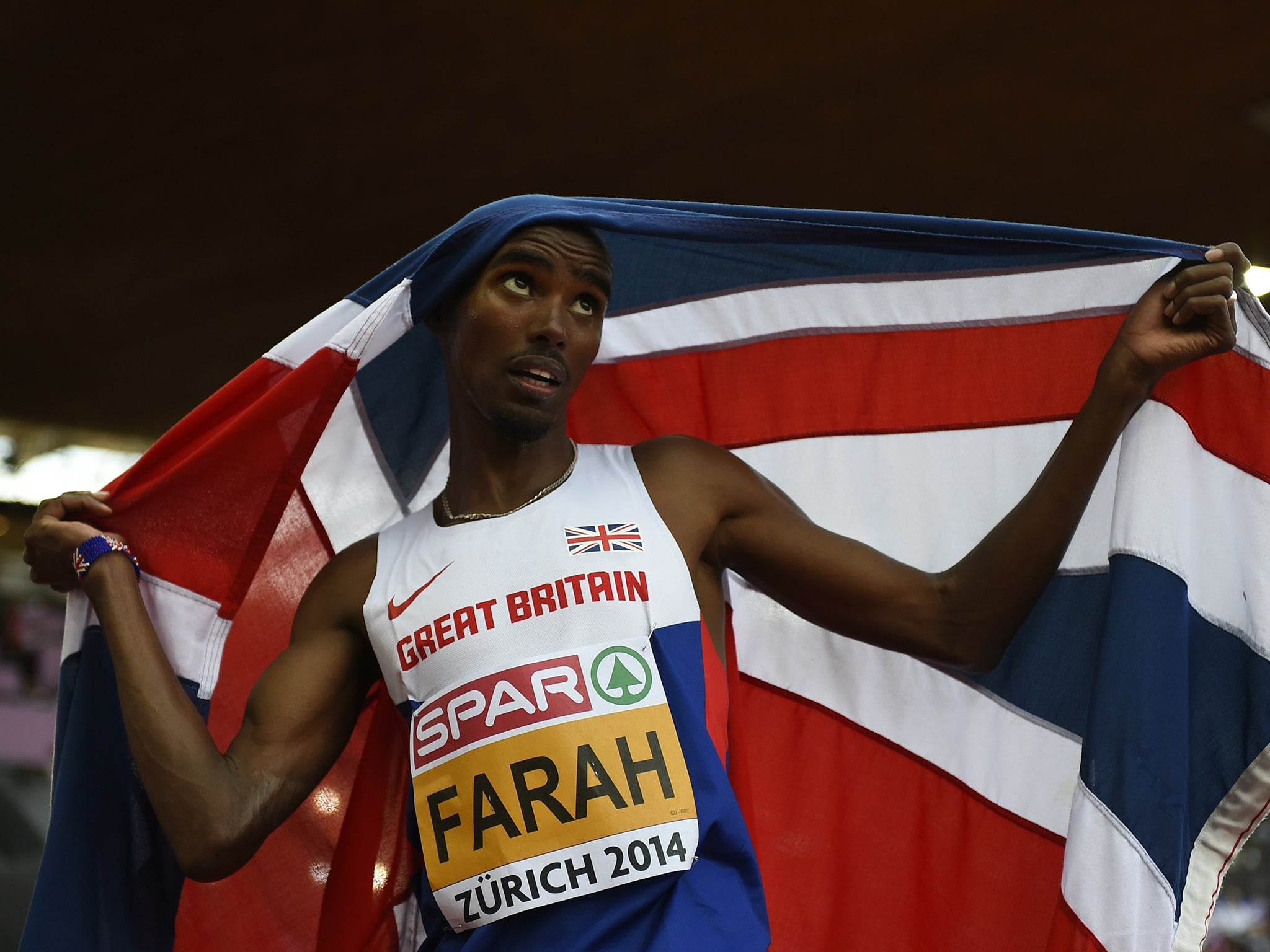 Great Britain's Mohamed Farah, holding his national flag, celebrates after winning the Men's 5000m final