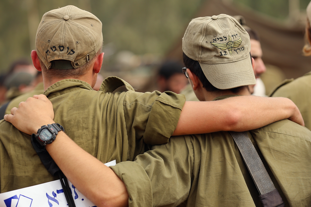 Two IDF soldiers dance to music provided by visiting Hassidic Jews who visited to show their support to soldiers at the border with the Gaza Strip