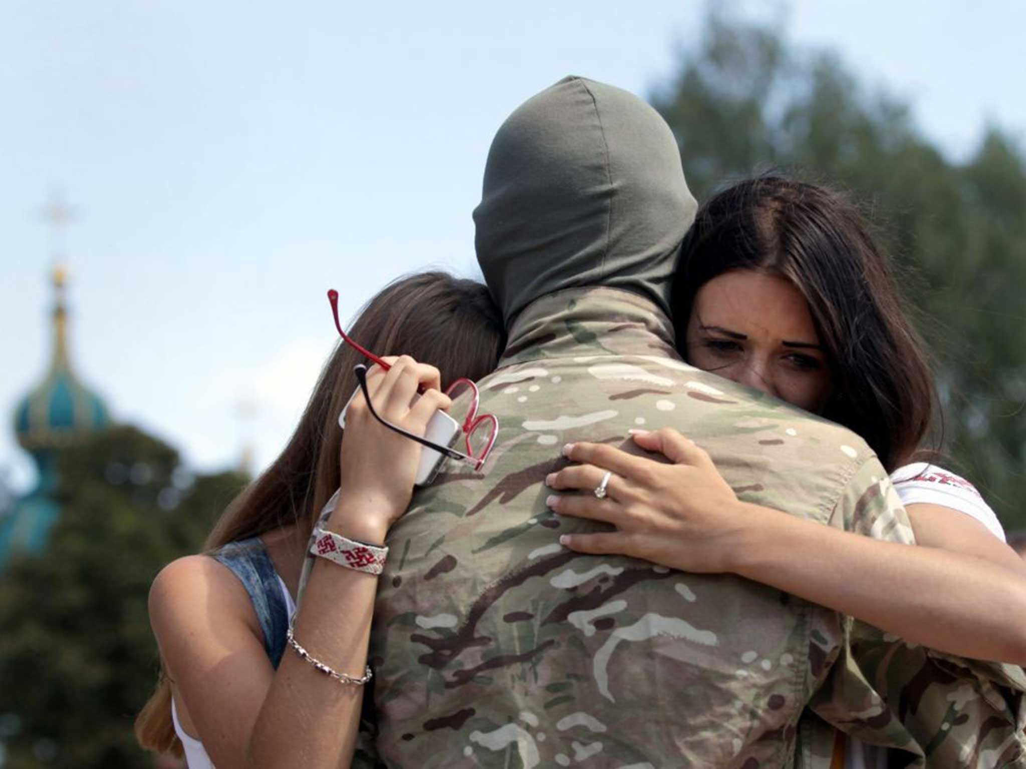 A member of the 'Azov' Battalion gets a farewell hug during a ceremony sending soldiers to eastern Ukraine