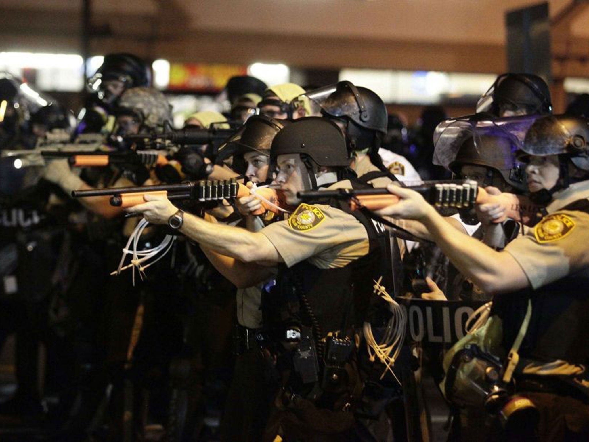 Officers point their weapons at protesters in Ferguson, Missouri