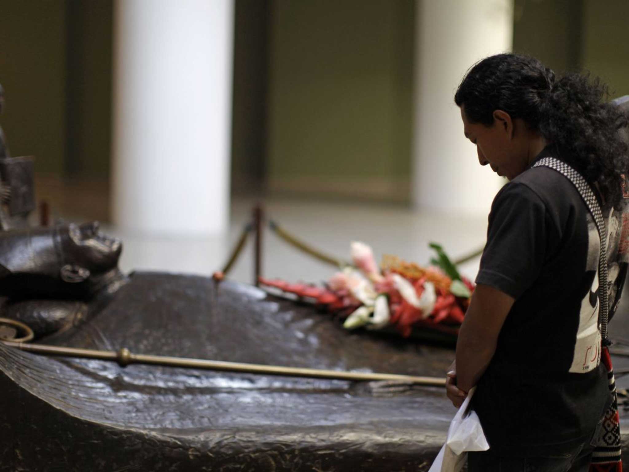 A man prays next to the tomb of slain Roman Catholic Archbishop Oscar Arnulfo Romero inside the national cathedral in San Salvador