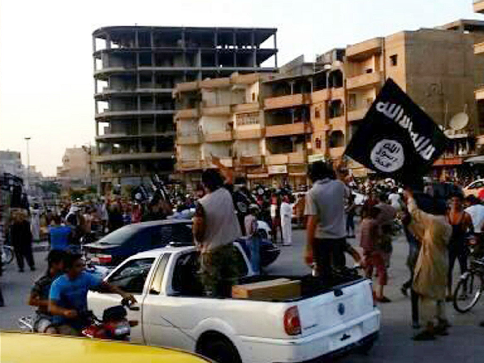 Isis fighters and supporters during a parade in Raqqa in June