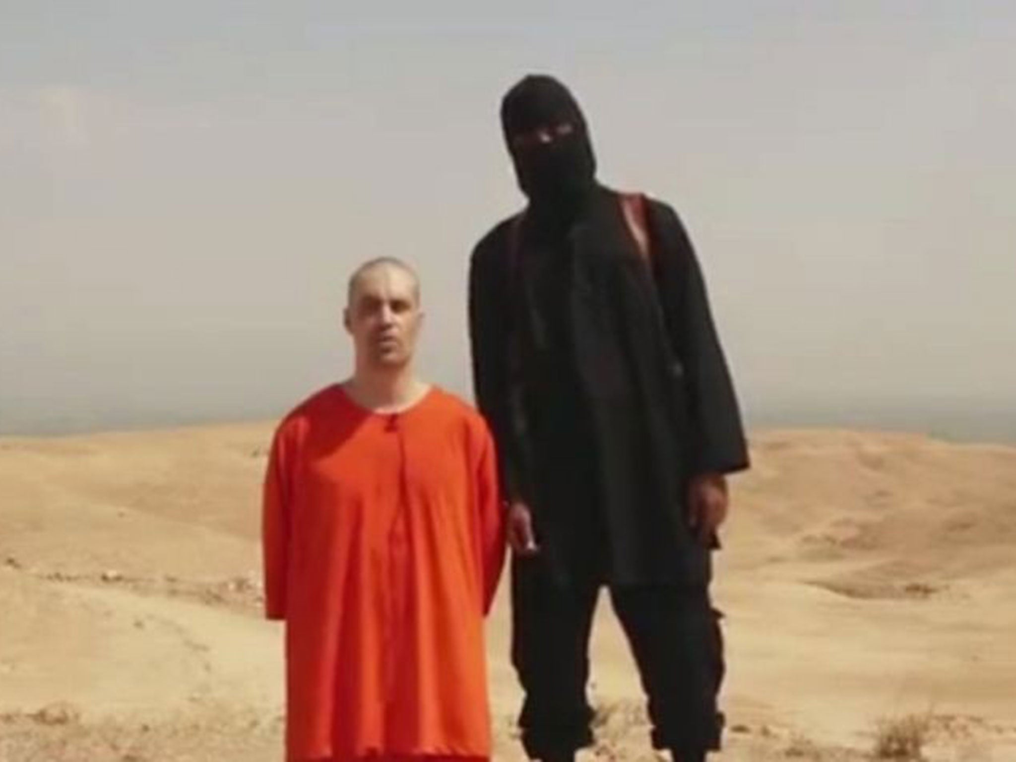 The video shows a man, thought to be James Foley, kneeling in front of a black-clad militant