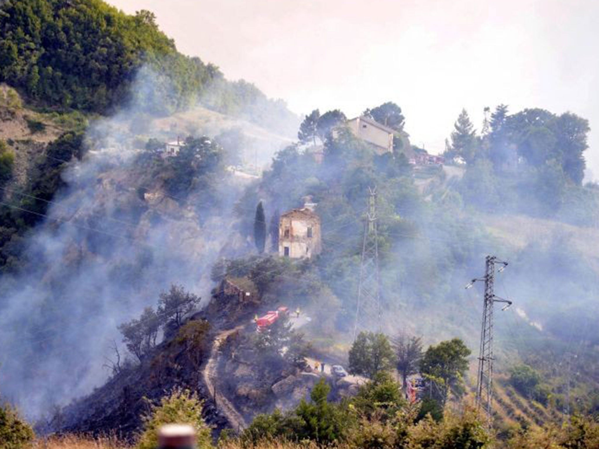 Firefighters at work after the collision of two Italian Air Force jets over the Marche region, Italy, 19 August 2014