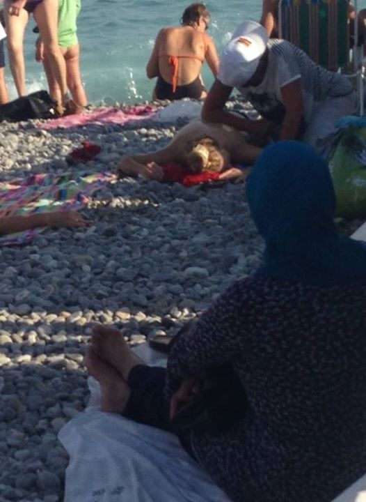 The picture taken by Nadine Morano: of a woman in a headscarf sitting on a beach