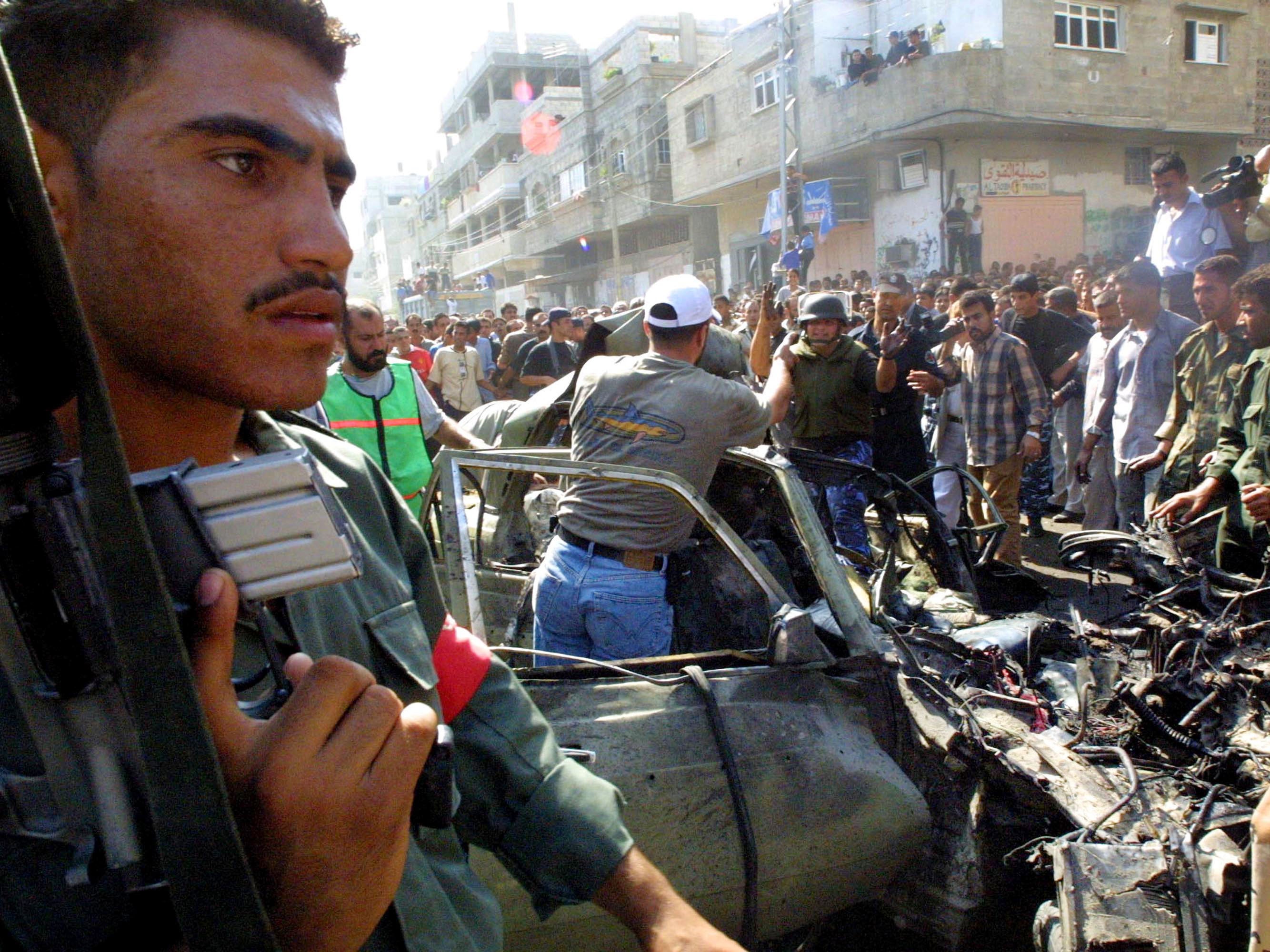 Palestinians inspect the wreckage of Mohammed Deif's car, after it was fired on by Israeli helicopter missiles September 26, 2002 in Gaza