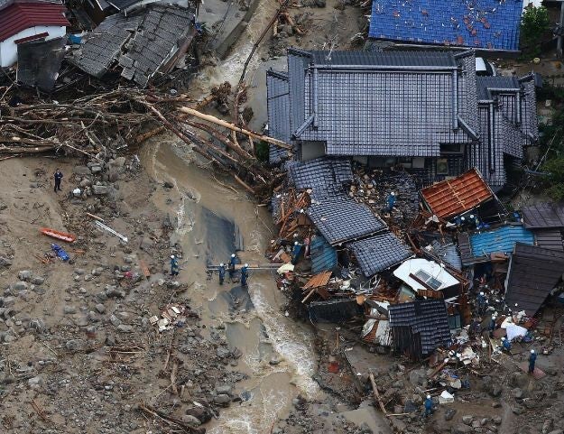 Rescue workers looking for survivors at the site of a landslide after heavy rains hit the city of Hiroshima, western Japan, on August 20