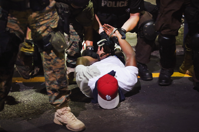 Police arrest a demonstrator protesting the killing of teenager Michael Brown in Ferguson, Missouri 