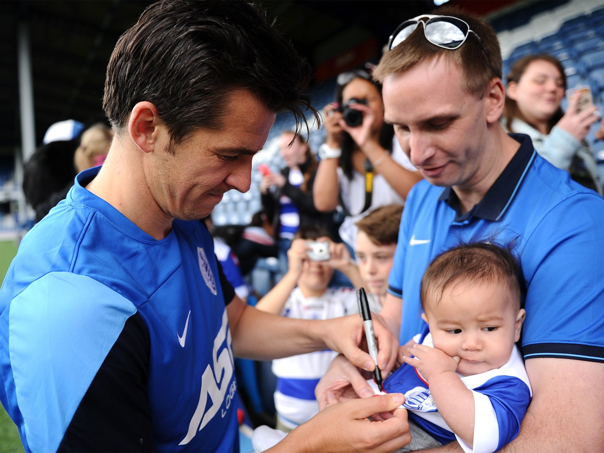 Joey Barton signs a baby’s shirt at QPR’s open day