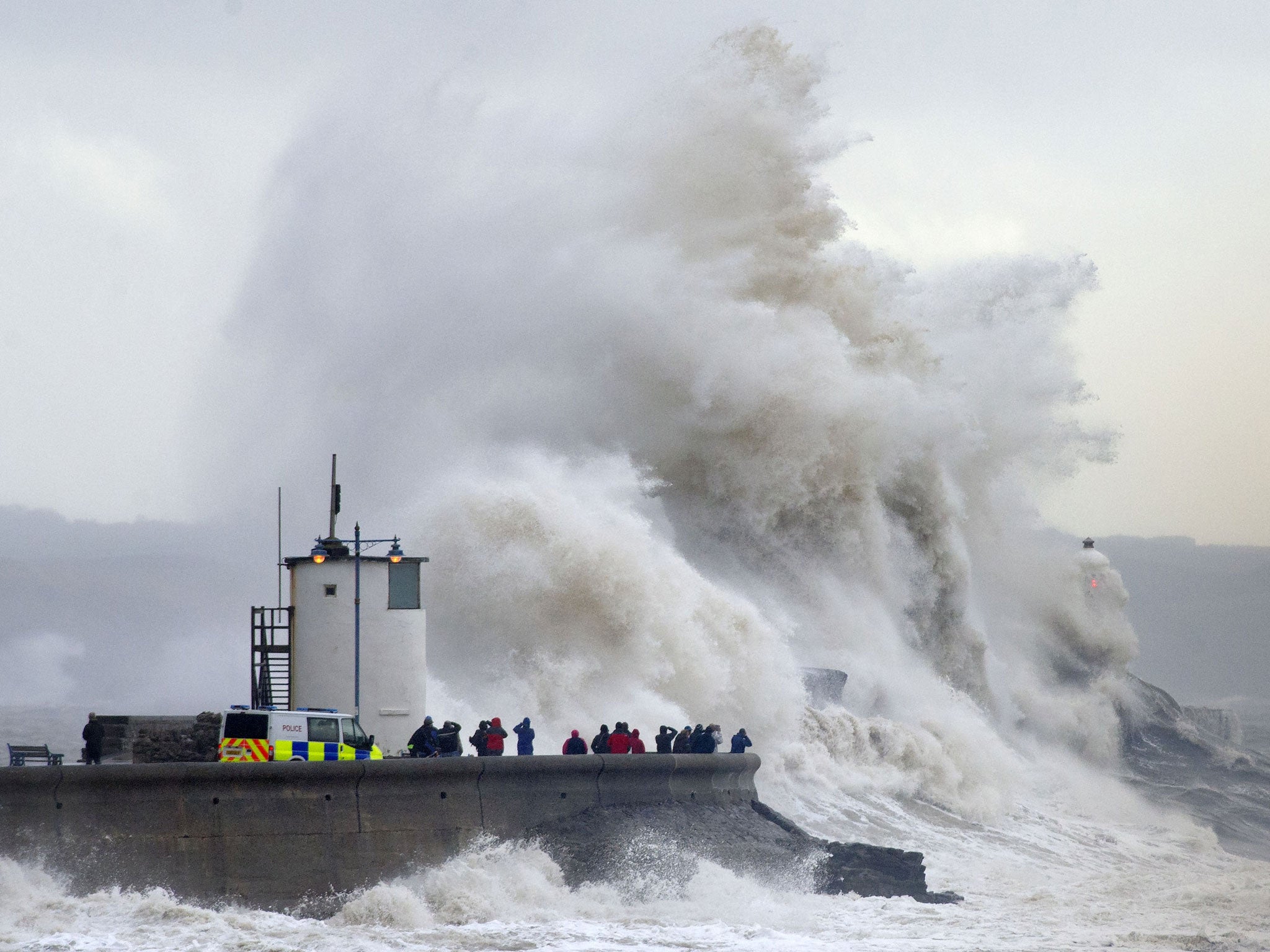 Waves break over the harbour wall at Porthcawl, Wales during a high tide on 5 February, 2014