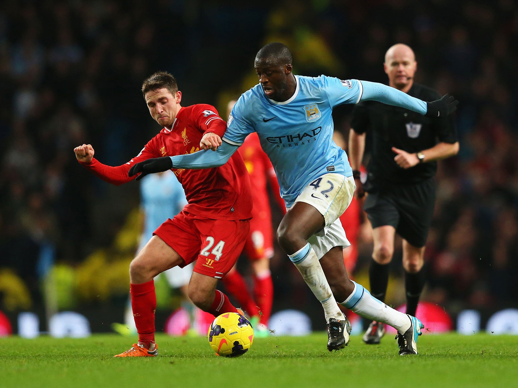 Yaya Toure of Manchester City is closed down by Joe Allen of Liverpool during the match between Manchester City and Liverpool at Etihad Stadium on December 26, 2013 in Manchester, England.