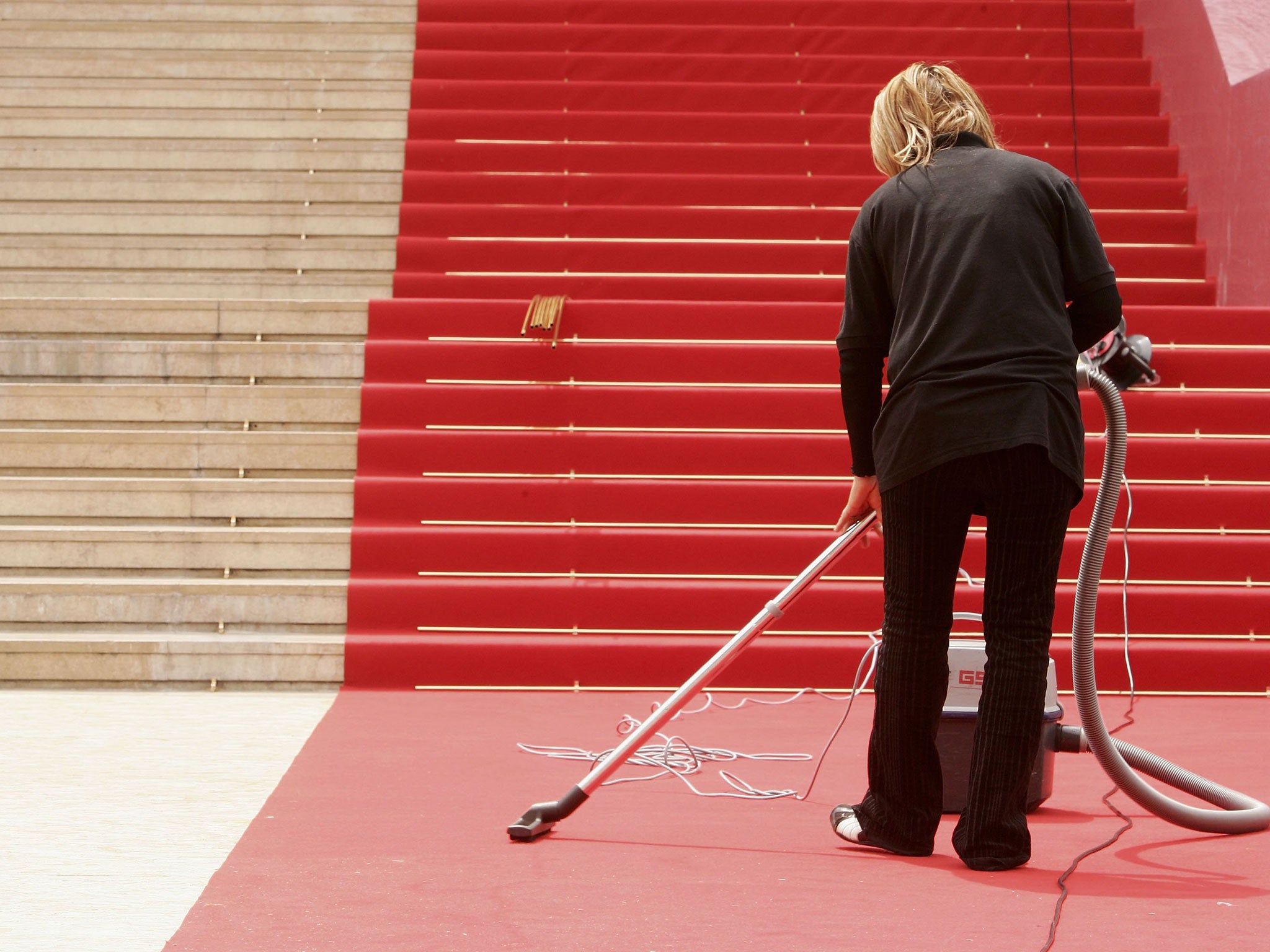 A cleaner prepares the red carpet for the opening night during the 59th International Cannes Film Festival May 17, 2006 in Cannes, France.