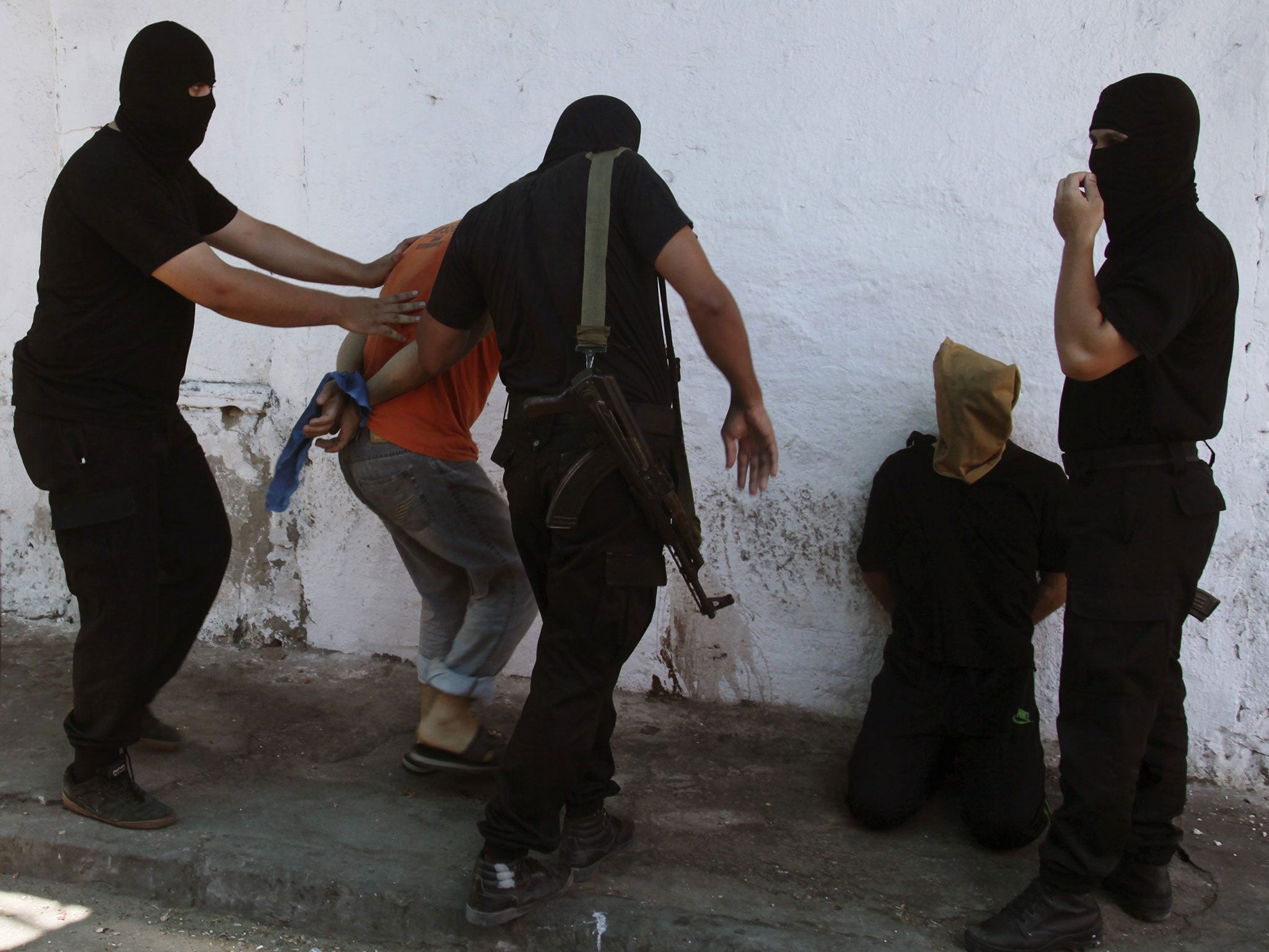 Hamas militants surround Palestinians suspected of collaborating with Israel before executing them in Gaza City August 22, 2014.