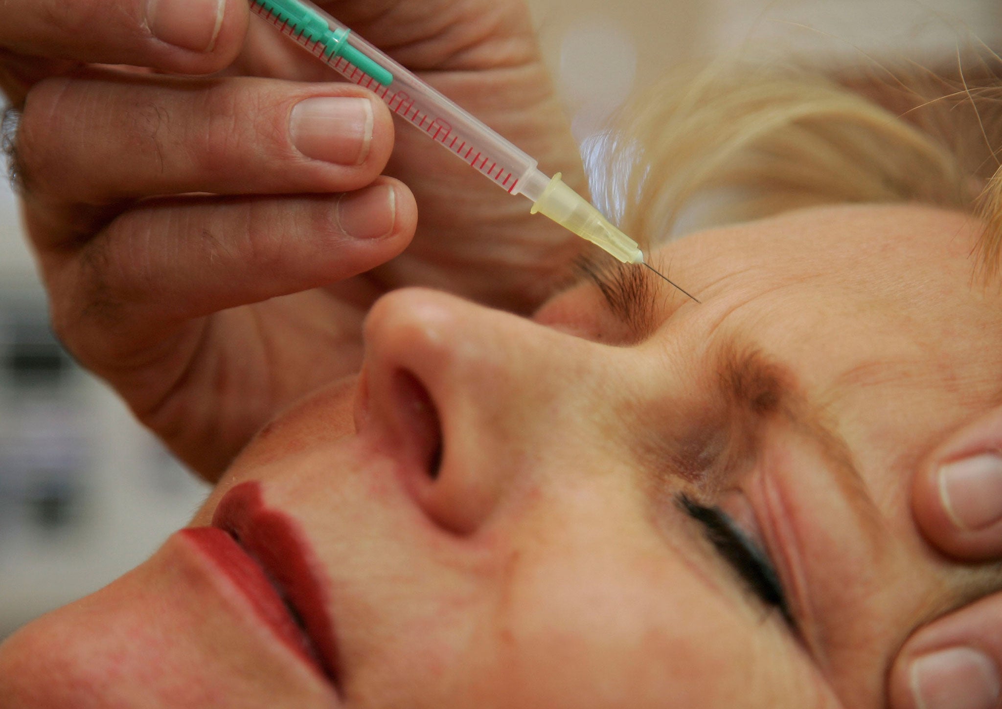 A doctor injects a patient with Botox at a cosmetic treatment center