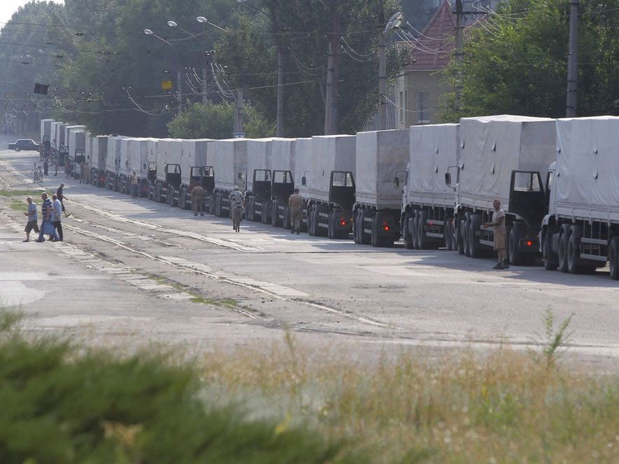 Drivers of the first trucks of the Russian aid convoy parked in the city of Luhansk on 22 August