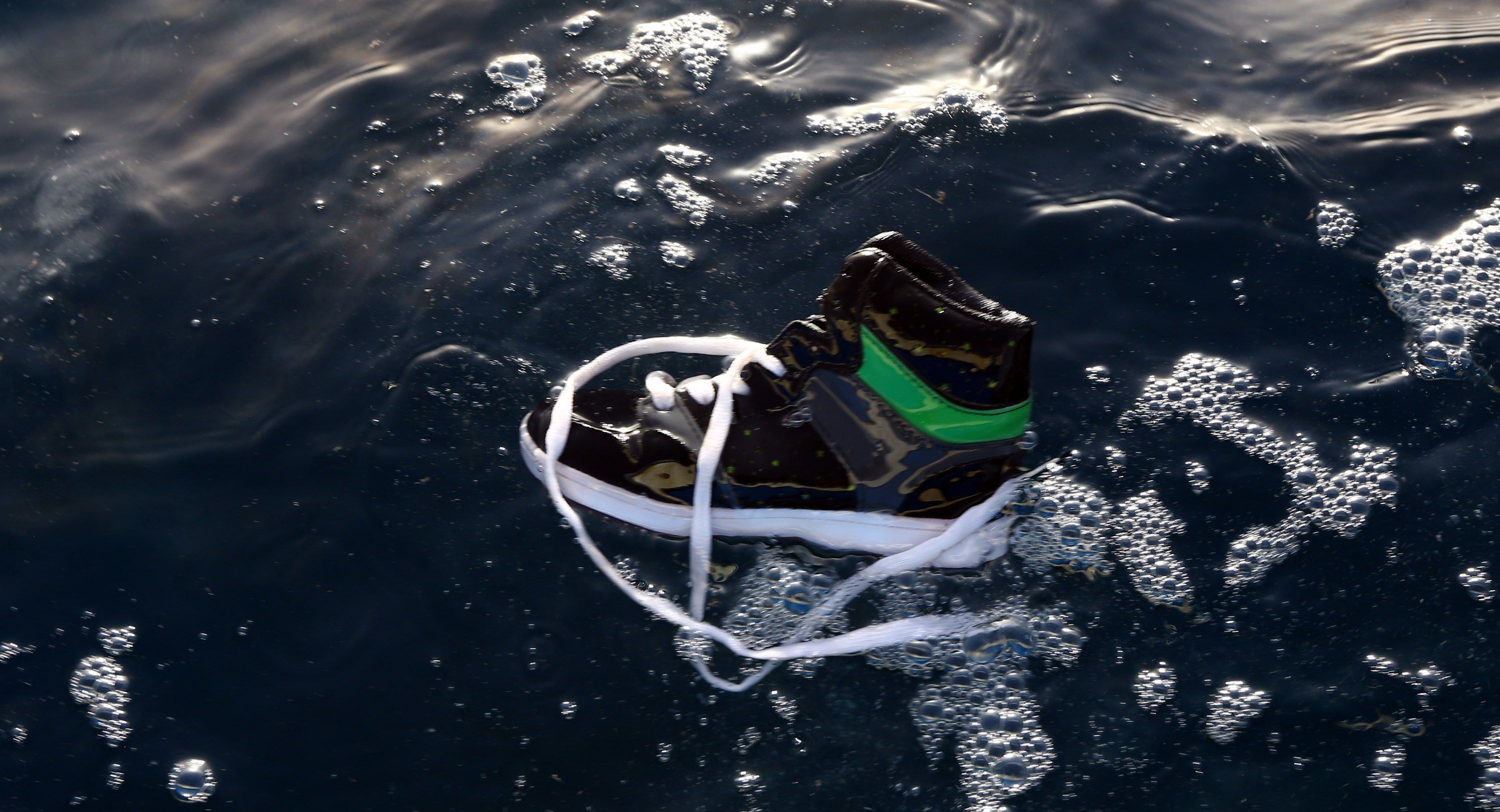A shoe floats in the water after a boat carrying 200 migrants sank off the coast of Libya