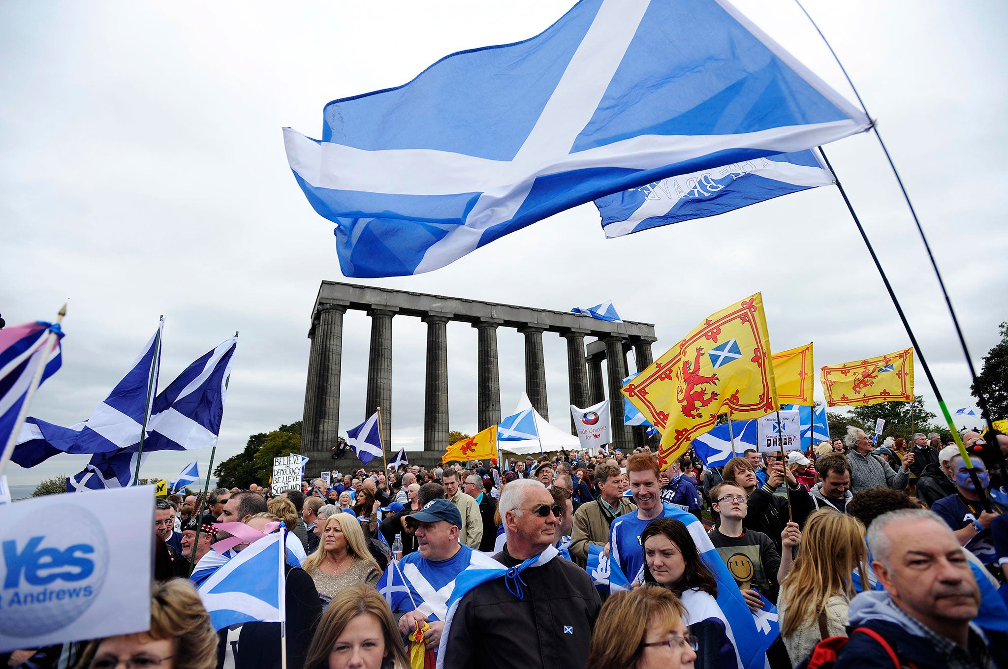 Pro-independence supporters wave the Saltire as they gather in Edinburgh on 21 September 2013