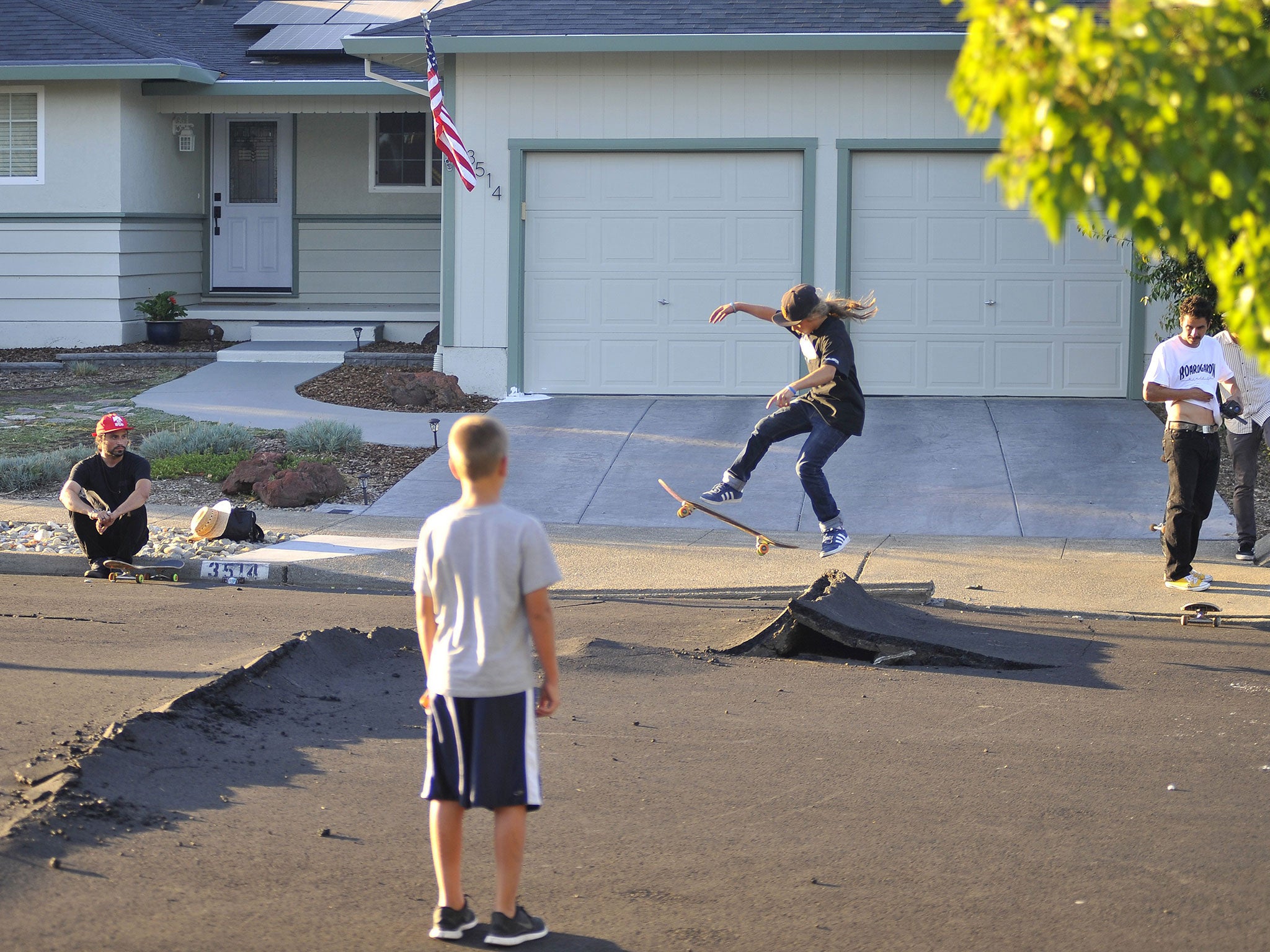 Kids skateboard over buckled roads in a residential neighborhood of Napa, California