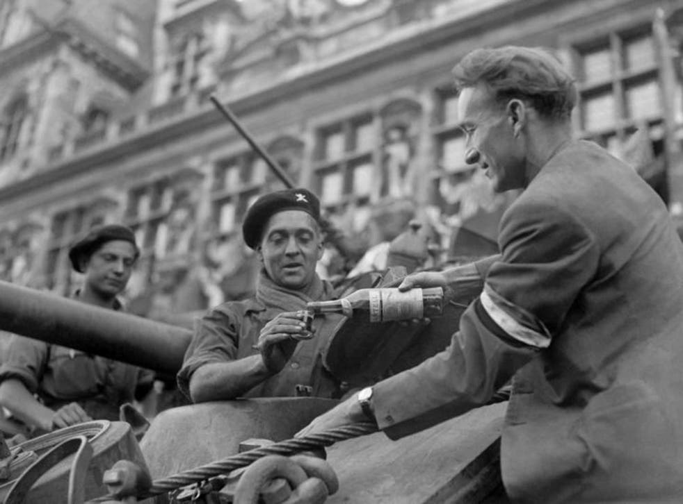 Vive la france! A civvy serves a victorious soldier a glass of cognac, after 1944’s Liberation of Paris