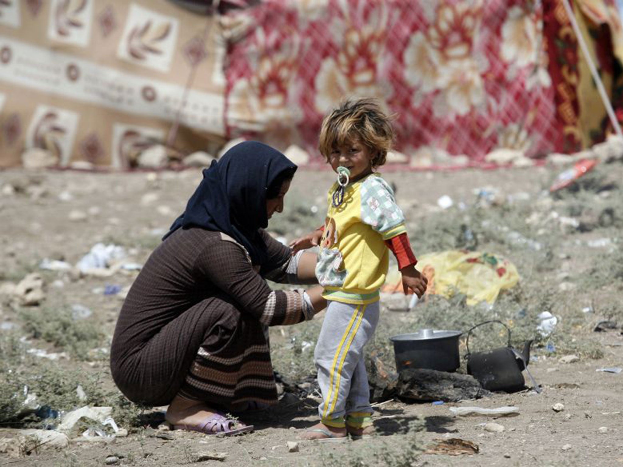 A Yazidi woman tries to cook in Zakho near the Iraqi-Turkish border