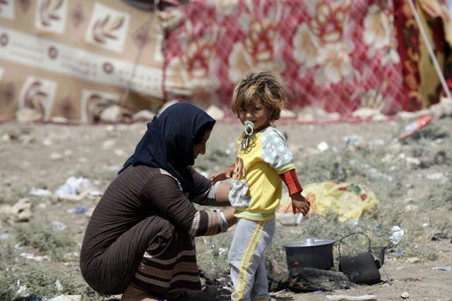 A Yazidi woman tries to cook in Zakho near the Iraqi-Turkish border 