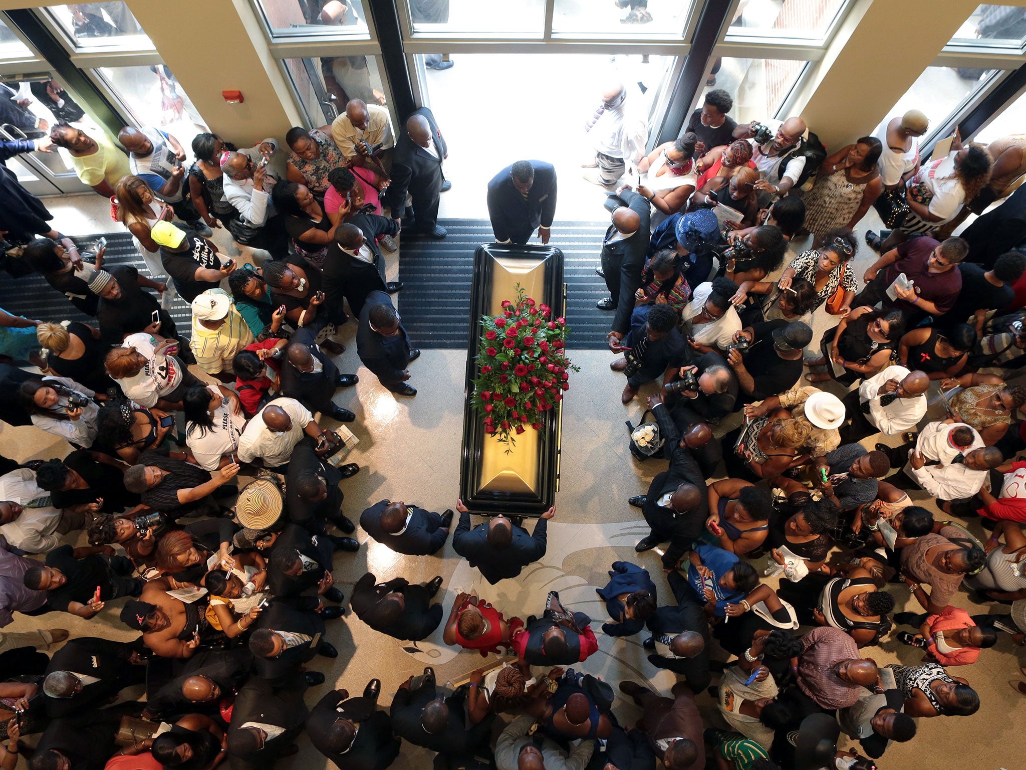 A casket containing the body of Michael Brown is wheeled out of Friendly Temple Missionary Baptist Church in St. Louis