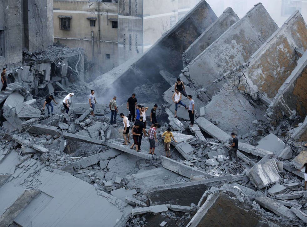 Palestinians inspect the remains of the destroyed Basha Tower on 26 August 2014