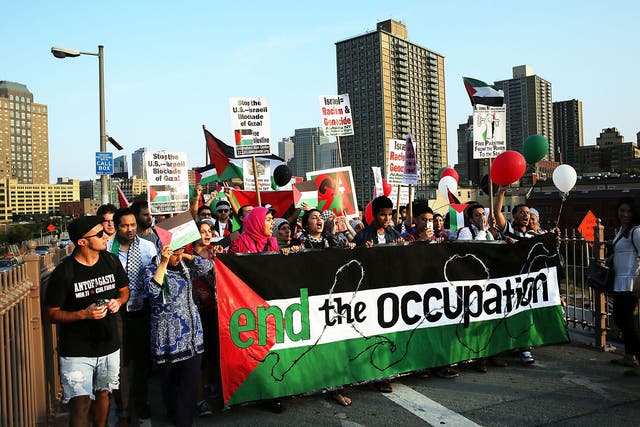 Demonstrators walk across the Brooklyn Bridge while protesting against Israel's continued military campaign in Gaza on August 20, 2014 in New York City.