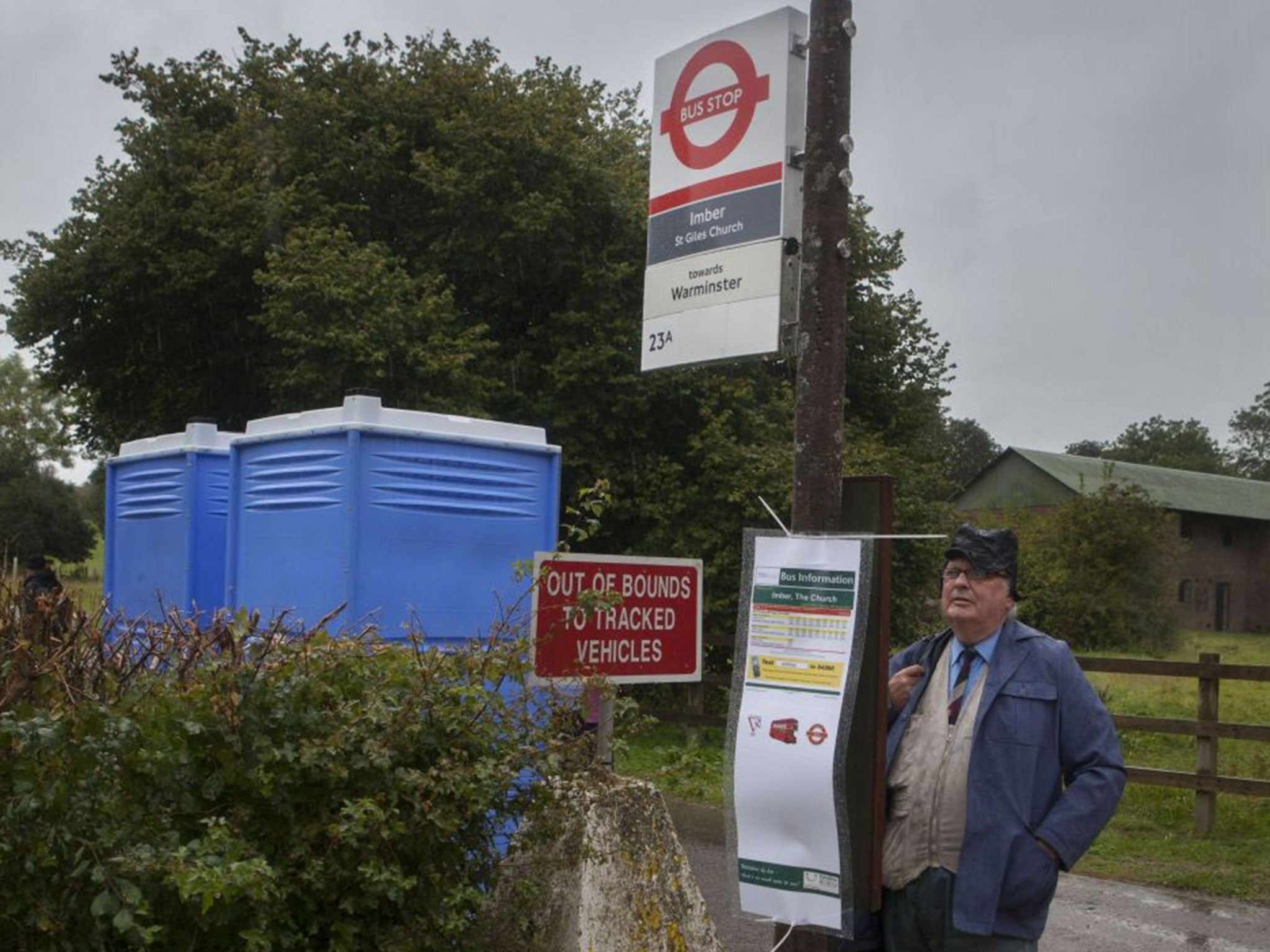 Hail fellow: a man waits at one of the specially made official London bus stop signs to catch the 23A to Imber