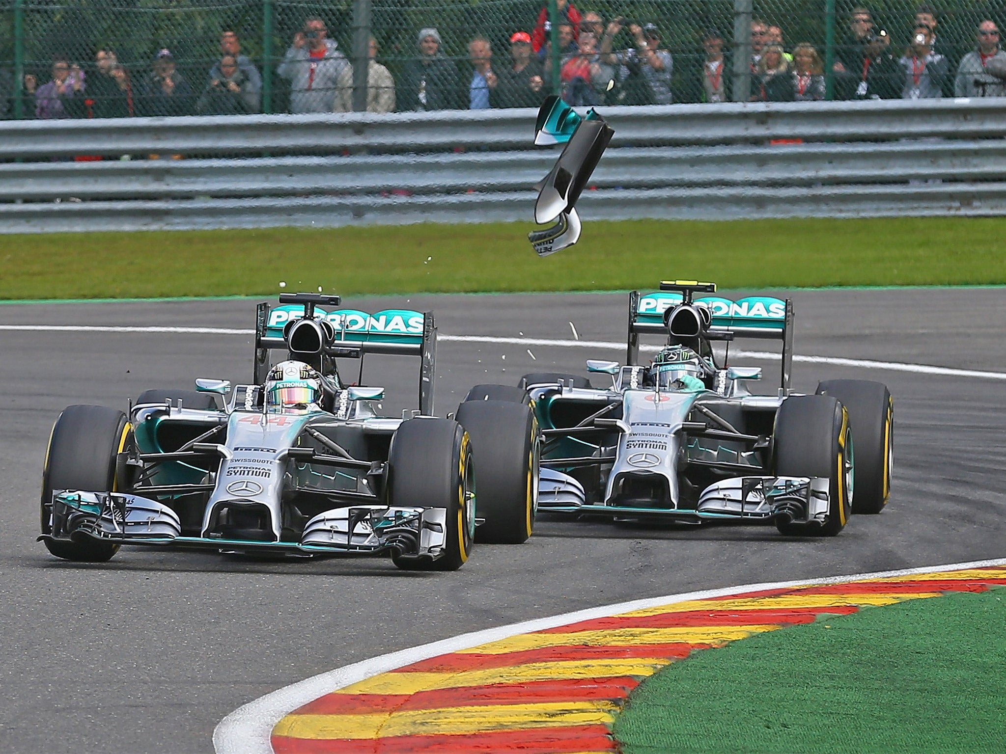 Debris flies from the car of Lewis Hamilton (left) after a collision with his Mercedes team-mate Nico Rosberg which led to the British driver’s retirement during Sunday’s Belgian GP