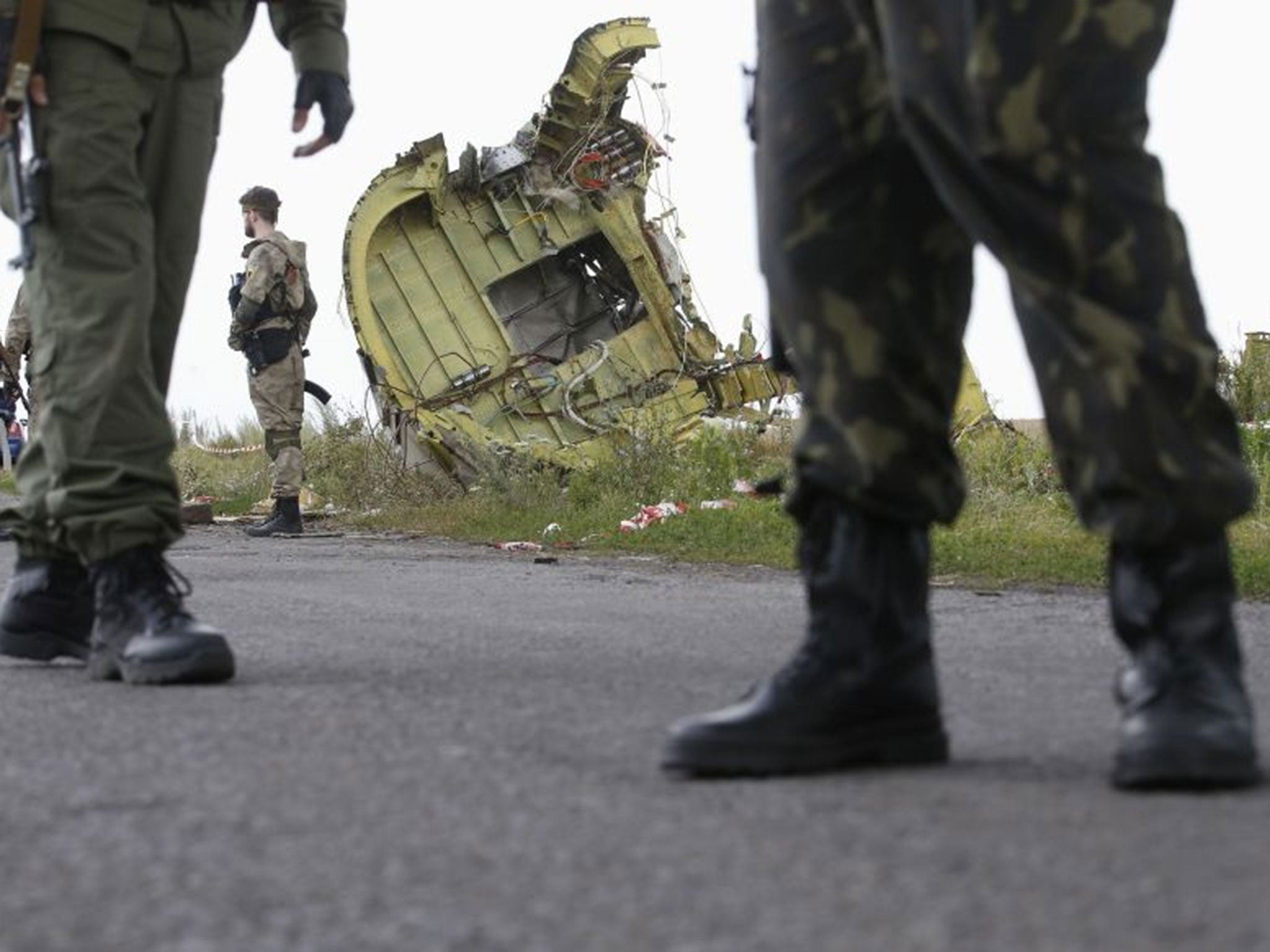 Armed pro-Russian separatists stand guard on the site where Malaysia Airlines Flight MH17 crashed
